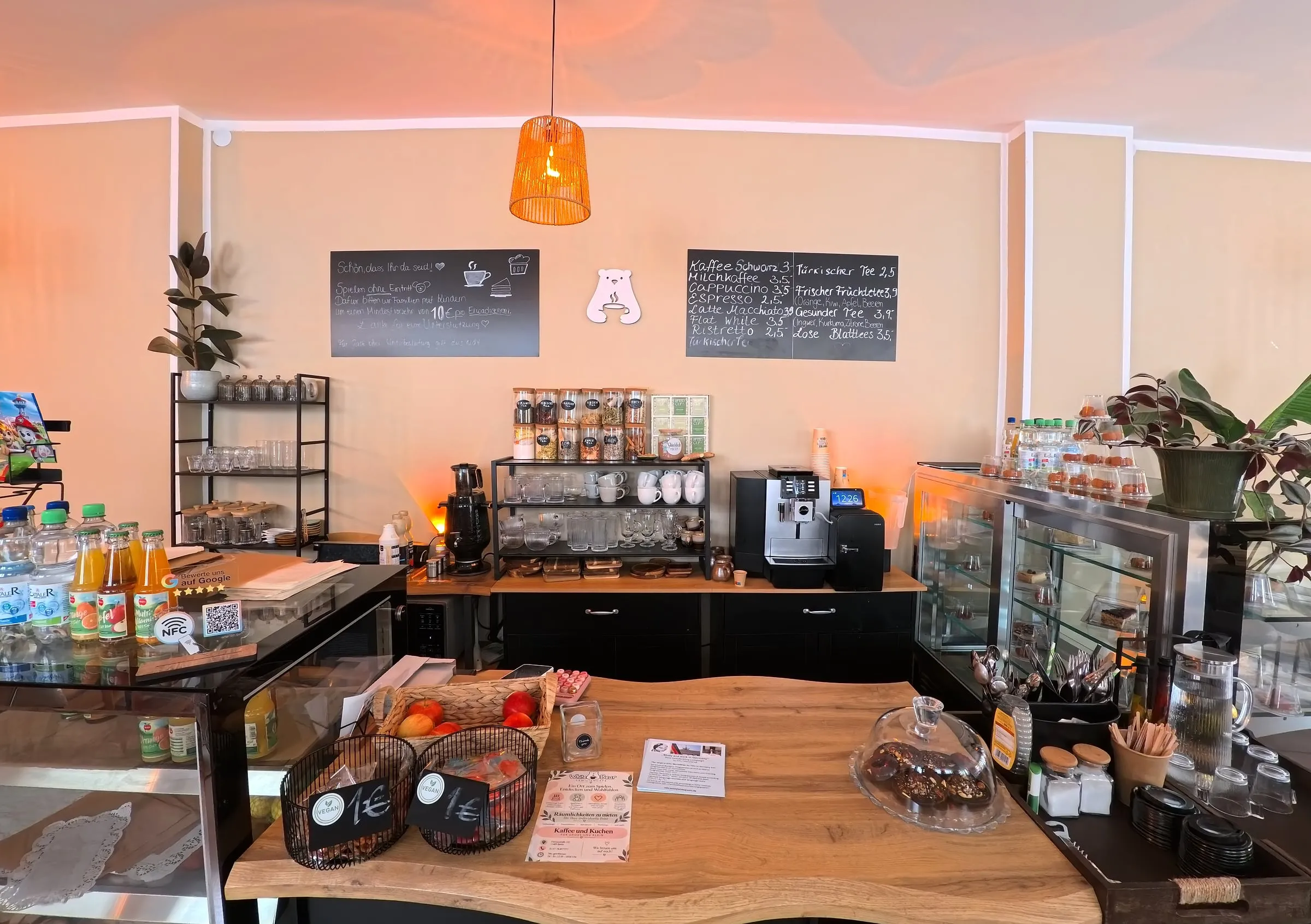 Die Theke mit Kaffeemaschine, Teegläsern, Kreidetafeln und dem Eisbär-Logo an der Wand